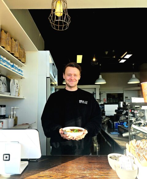 Josh Andrew holds a steaming bowl of congee at 5 Little Pigs Cafe in Huskisson. Photo: Narrell Tabone