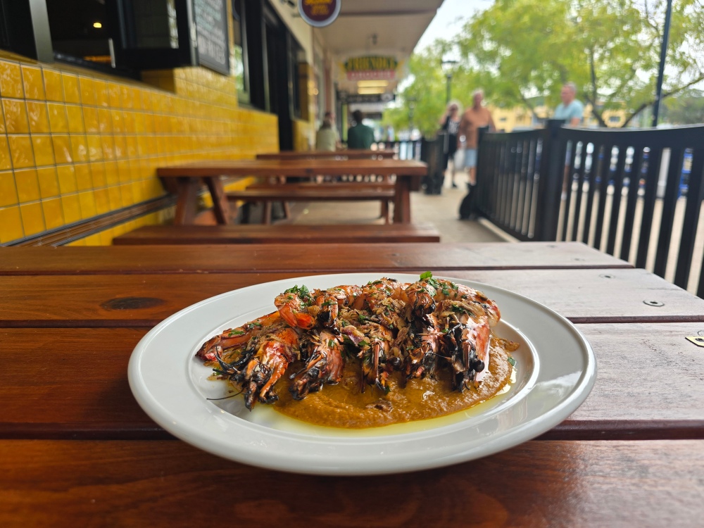 Char-grilled tandoori tiger prawns served with yogurt and lemon on a table at Bud’s Tavern in Huskisson. Photo Narrell Tabone
